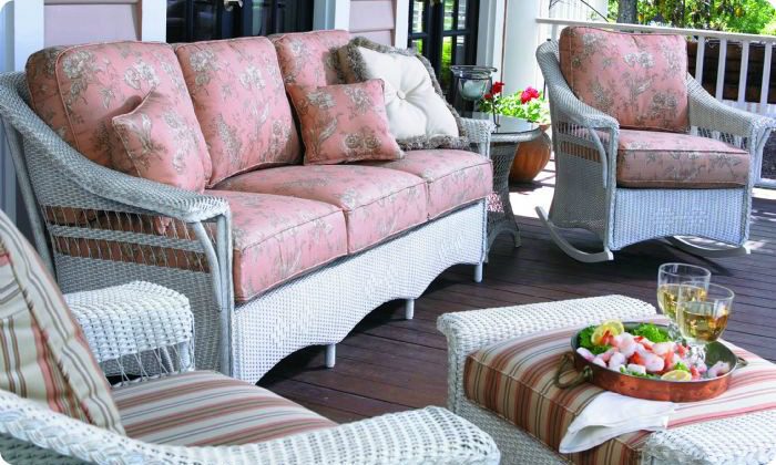pink cushions on a white wicker outdoor couch