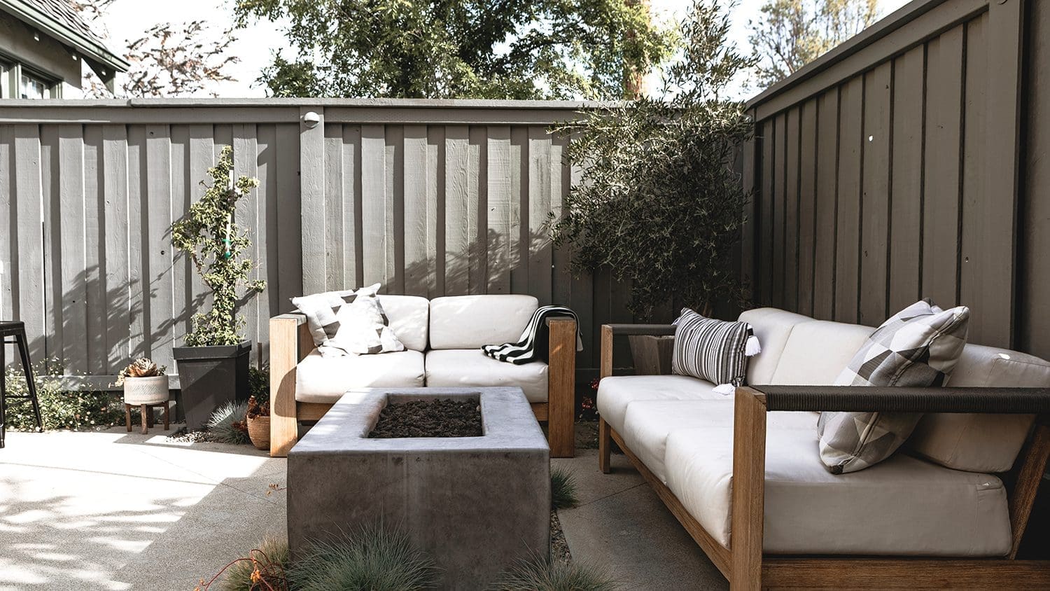 an outdoor couch with thick white cushions on it and accent pillows with gray designs