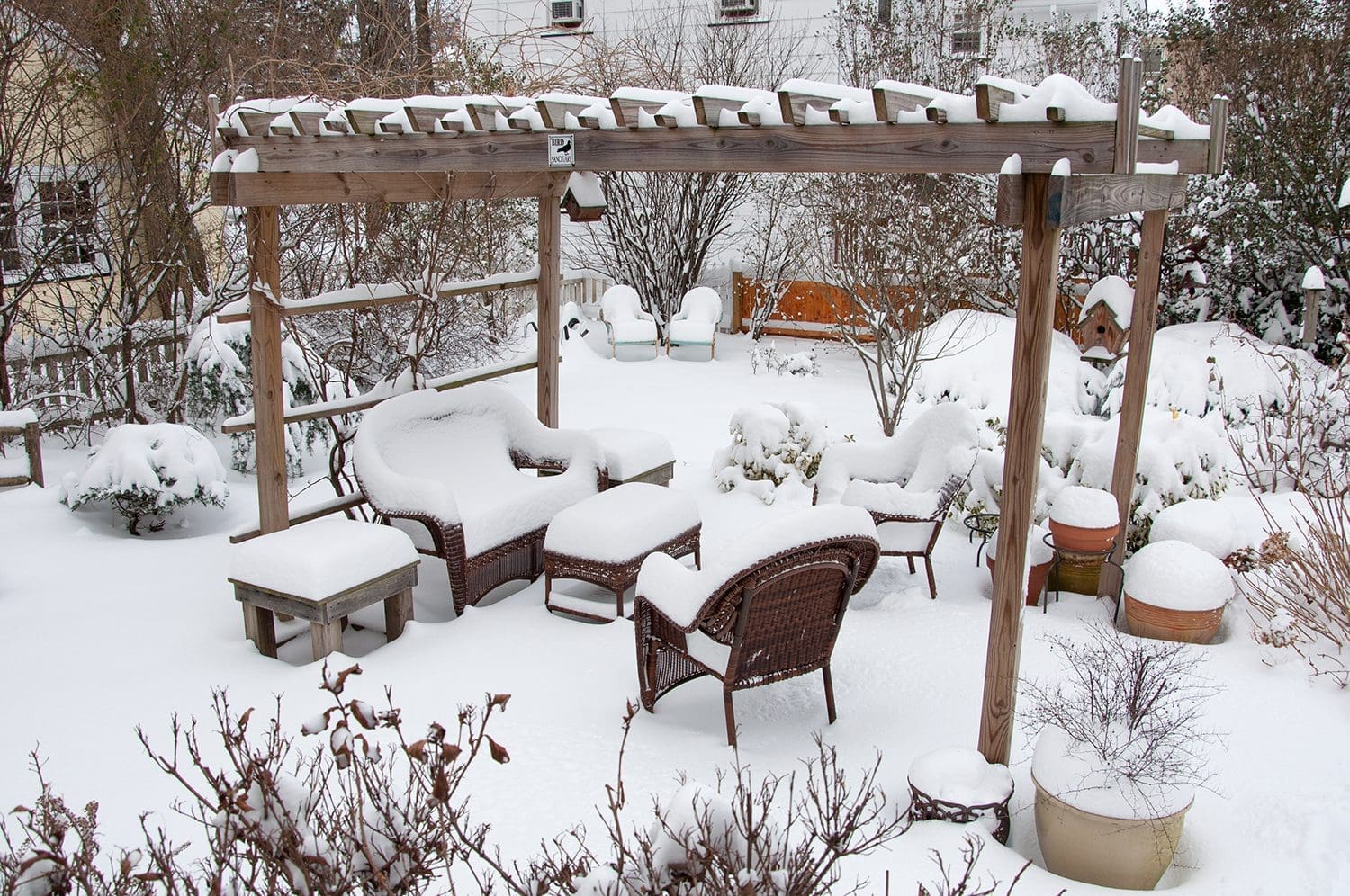 A backyard patio furniture set covered in snow.